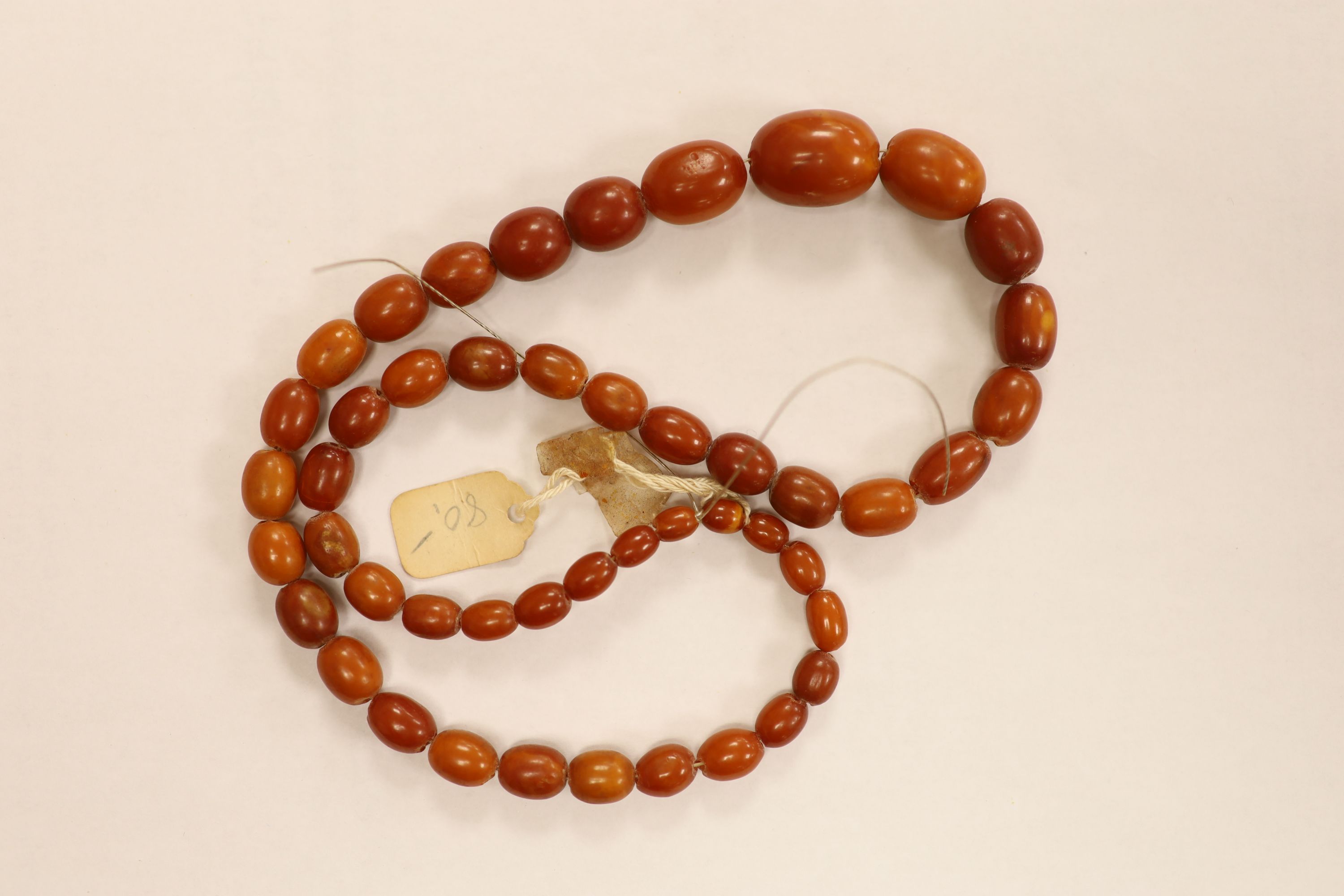 Nine assorted single strand amber bead necklaces, longest approximately 46cm, gross weight 173 grams and one simulated amber bead necklace.